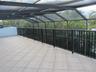 Screened-in balcony featuring tile flooring, metal structural framing, and a black vertical-slat railing