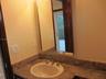 Upstairs bathroom Stone-finish countertop with an integrated basin, high-arch polished chrome faucet, and rectangular wall-mounted mirror