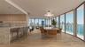 Living area featuring recessed ceiling lighting, a textured accent wall, integrated media cabinetry, floor-to-ceiling windows, and an exterior stone w