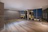 Floor-to-ceiling glass windows, wide-plank wood-finish flooring, recessed LED ceiling lighting, minimalist linear lighting fixture, and neutral wall s