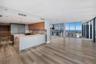 Floor-to-ceiling windows, wood-finish flooring, recessed lighting, and expansive glass balcony railings