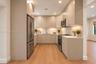 Kitchen featuring flat-panel cabinetry, light-toned countertops, recessed lighting, and stainless steel appliances including a refrigerator, range, an