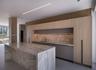 Open-concept space featuring floor-to-ceiling glass panel walls, wood-finish flooring, recessed square lighting, linear cove lighting, and a wall-moun