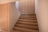 Architectural ceiling featuring a metallic circular pendant light fixture and textured stone-finish tiling