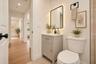 Grey vanity with a light-toned countertop, rectangular undermount sink, matte black faucet, and backlit rectangular mirror