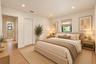 Neutral-toned interior featuring recessed lighting, wood-finish flooring, and a window with a roller shade
