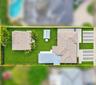 Aerial perspective featuring a white exterior residence, expansive lawn, multi-vehicle concrete parking area, and mature landscape