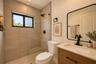 Neutral interior featuring recessed lighting, a window with woven shade, and solid-surface flooring