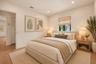 Neutral-toned interior featuring wood-finish flooring, recessed lighting, and a window with a woven shade