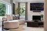 Living area featuring a floor-to-ceiling window, large-format stone fireplace surround, and recessed ceiling lighting