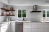 Kitchen featuring white flat-panel cabinetry, stone countertops, stainless steel appliances, a stainless steel range hood, and wood-finish floating co