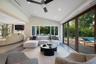 Living area featuring a vaulted ceiling, recessed lighting, wood-finish flooring, and expansive folding glass doors opening to the exterior deck