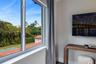 Casement window featuring white frames and custom wall-mounted television