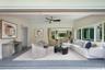 Open-concept interior featuring large-format retractable glass walls, recessed lighting, ceiling fan, and painted walls