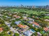 Aerial perspective of the residence next to prestigious La Gorce golf club, mature landscaping situated within a coastal urban environment