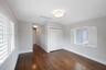 Room featuring wood-finish flooring, white plantation shutters, dual-door closet, and drum-style ceiling lighting