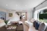 Open-concept interior featuring recessed lighting, curved architectural wall detail, wood-finish flooring, and expansive picture window