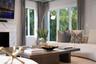 Living area featuring a floor-to-ceiling stone-surround fireplace, large windows, and neutral wall tones