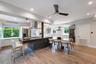 Gourmet kitchen featuring a large central island with stone-finish countertop, stainless steel appliances, wood-finish flooring, recessed lighting, an