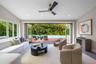 Multi-panel folding glass doors, recessed lighting, ceiling fan, and access to a wood-decked pool area