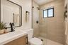 Bathroom featuring a wood-finish vanity with a white countertop, matte black hardware, a glass-enclosed shower with large-format tile surround, and a 
