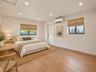 Wood-finish flooring, recessed lighting, dual windows with Roman shades, and a wall-mounted ductless mini-split system