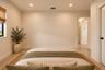 Neutral-toned interior room featuring recessed ceiling lighting and a single-panel interior door with matte black hardware