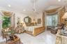 Vaulted ceilings featuring ornate crown molding, light-toned stone tile flooring, a central ceiling fan, recessed lighting, and large windows