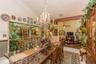 Vaulted ceiling featuring crown molding, prominent crystal chandelier, and integrated fireplace with brick surround
