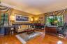 Hardwood flooring, crown molding, chair rail, and multiple oversized windows with greenery exposure