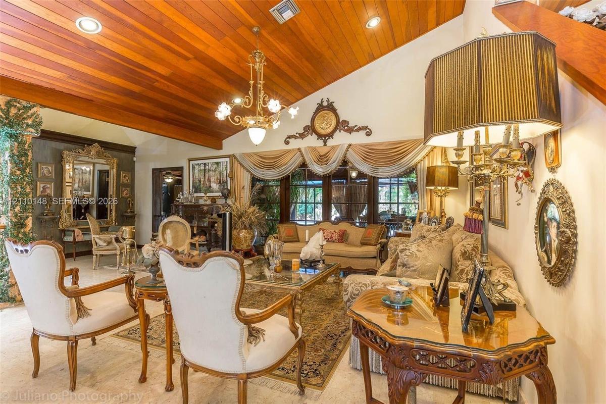 Vaulted wood-plank ceiling featuring recessed lighting and a central multi-arm chandelier