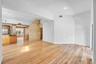 Open floor plan featuring wood-finish flooring, recessed lighting, and a neutral color palette with textured stone-finish accent walls