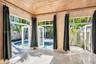 Sunroom featuring a vaulted wood-paneled ceiling, large-format tile flooring, and multiple glass-paned doors with transoms