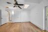 Wood-finish flooring, ceiling fan with integrated lighting, skylight, and multi-panel interior doors