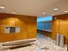 Wood-paneled walls with integrated mailboxes, recessed ceiling lighting, and a marble-patterned floor
