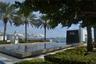 Expansive water feature with stone surround, complemented by manicured landscaping and mature palm trees