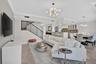 Open-concept living space featuring high ceilings, crown molding, and large format floor tile.