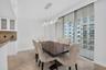 Contemporary chandelier illuminates the dining area with a view.