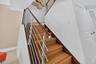 Wood-finish stairs with a stainless steel and wood railing.