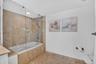 Bathtub with glass shower enclosure.