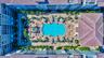 Resort-style courtyard featuring a large swimming pool, surrounding lounge areas, and lush landscaping