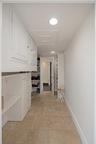 Storage area featuring stone-finish flooring, custom built-in white cabinetry, integrated drawer banks, and recessed lighting