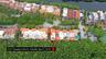 Aerial perspective of property featuring a multi-story structure with a terra cotta tile roof, positioned on a waterfront lot with dense perimeter lan