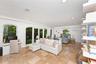 Spacious interior featuring stone tile flooring, recessed lighting, arched windows, dual-pane glass French doors, and white built-in wall shelving