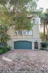 Stucco exterior featuring arched windows, a multi-level silhouette, a dedicated garage, and a brick-paved driveway