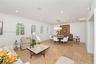 Open-concept space featuring stone tile flooring, crown molding, recessed lighting, and four arched windows with shutter treatments
