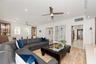 Open-concept interior featuring natural stone flooring, recessed lighting, ceiling fans, arched windows, and built-in cabinetry with glass-front displ