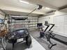 Multi-car garage featuring epoxy-coated flooring, built-in wall shelving, and dual sets of louvered-door closets