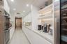 Sleek kitchen featuring flat-panel cabinetry, stone countertops, integrated stainless steel double wall ovens, built-in recessed shelving with under-c