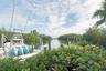 Waterfront property featuring a private boat dock, wooden pilings, and dense coastal vegetation